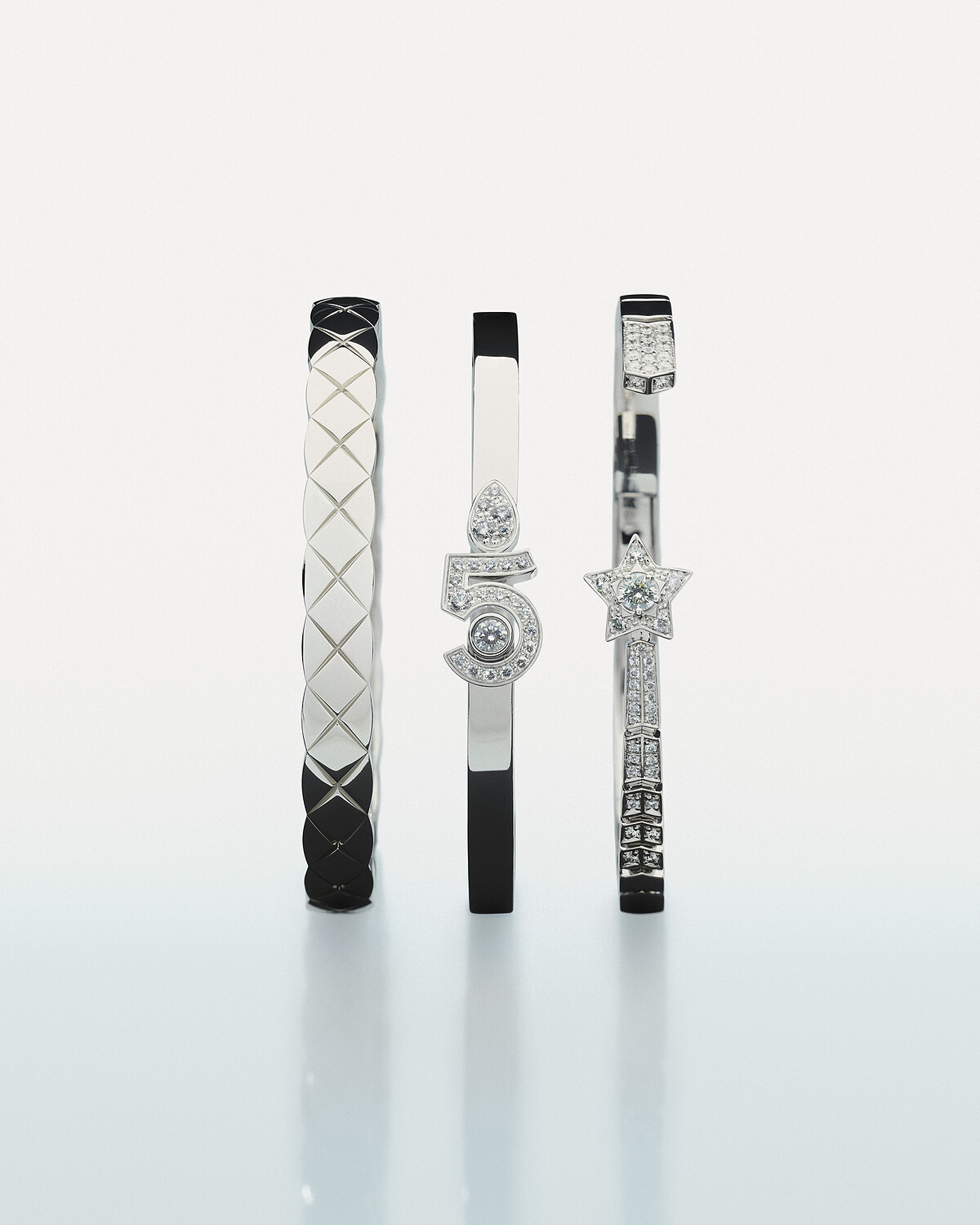 (由左至右) COCO CRUSH手環 18K白金, 建議售價 NTD 317,000 元 。 ETERNAL N°5手環 18K白金鑲嵌鑽石, 建議售價 NTD 380,000 元 。 COMÉTE 流星開放式手鐲 18K白金,中央鑲嵌一顆重約 0.15 克拉鑽石,及 48 顆總重約 0.54 克拉鑽石, 建議售價 NTD 586,000 元