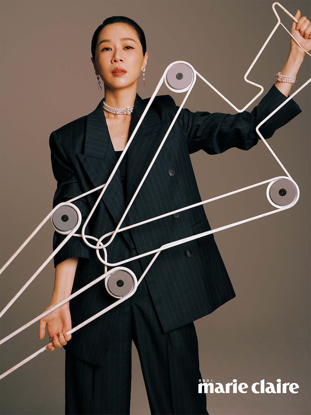 深色西裝外套，Ferragamo；Les P&eacute;tales Place Vend&ocirc;me Ros&eacute;s 18K粉紅金鑲鑽珍珠垂墜耳環、Les P&eacute;tales Place Vend&ocirc;me Ros&eacute;s 18K粉紅金鑲鑽珍珠手鍊、Les P&eacute;tales Place Vend&ocirc;me Ros&eacute;s 18K粉紅金鑲鑽珍珠短項鍊，all by MIKIMOTO。