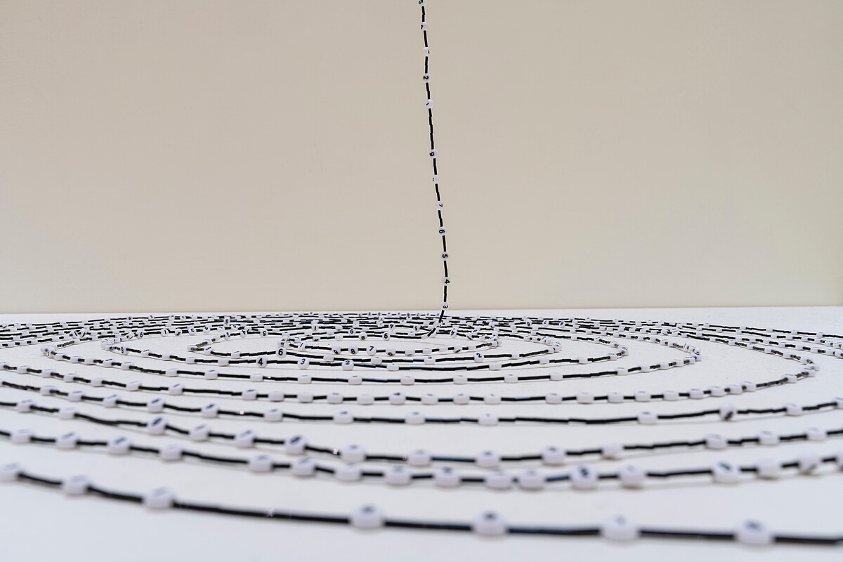 宮島達男〈無限計數之珠〉，自貫穿樓層的三角形天井垂落地面。