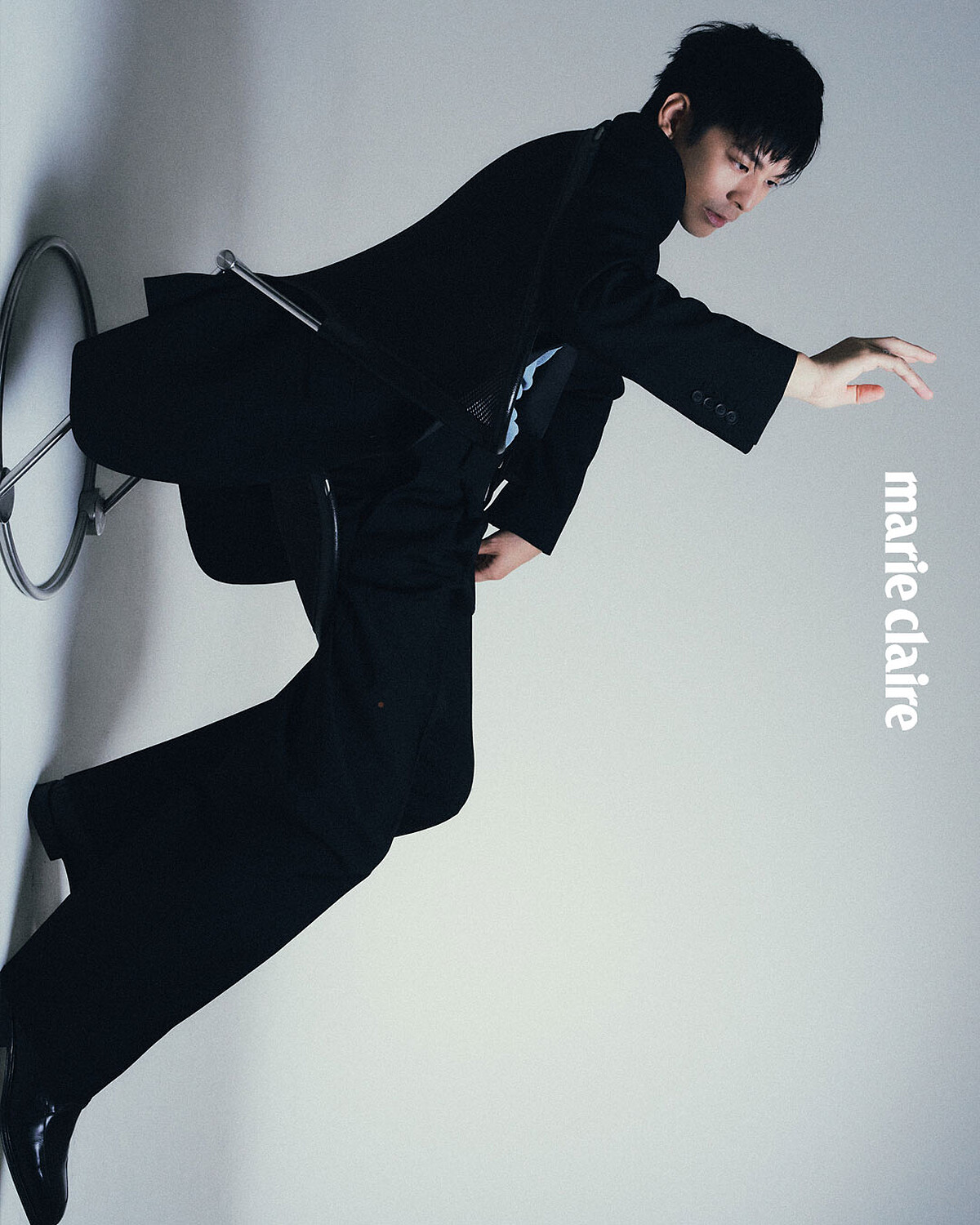 深色西裝外套、深色西裝長褲、天藍色針織上衣、黑色皮鞋，all by Ferragamo。