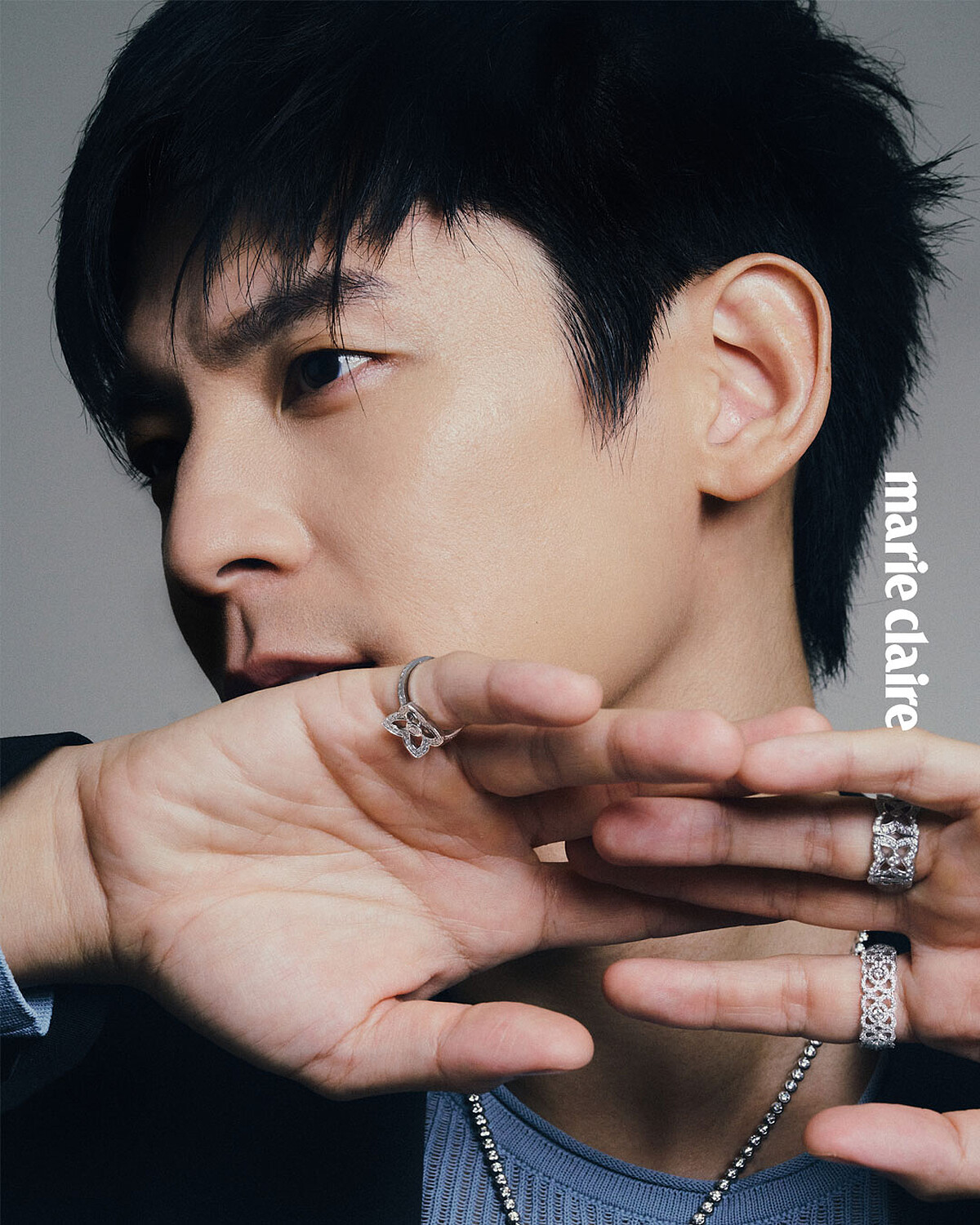 Lotus by DE BEERS 系列白金鑽石戒指、高級珠寶鑽石胸針搭配包鑲鑽石項鍊，all by De Beers London；深色西裝外套、天藍色針織上衣，both by Ferragamo。