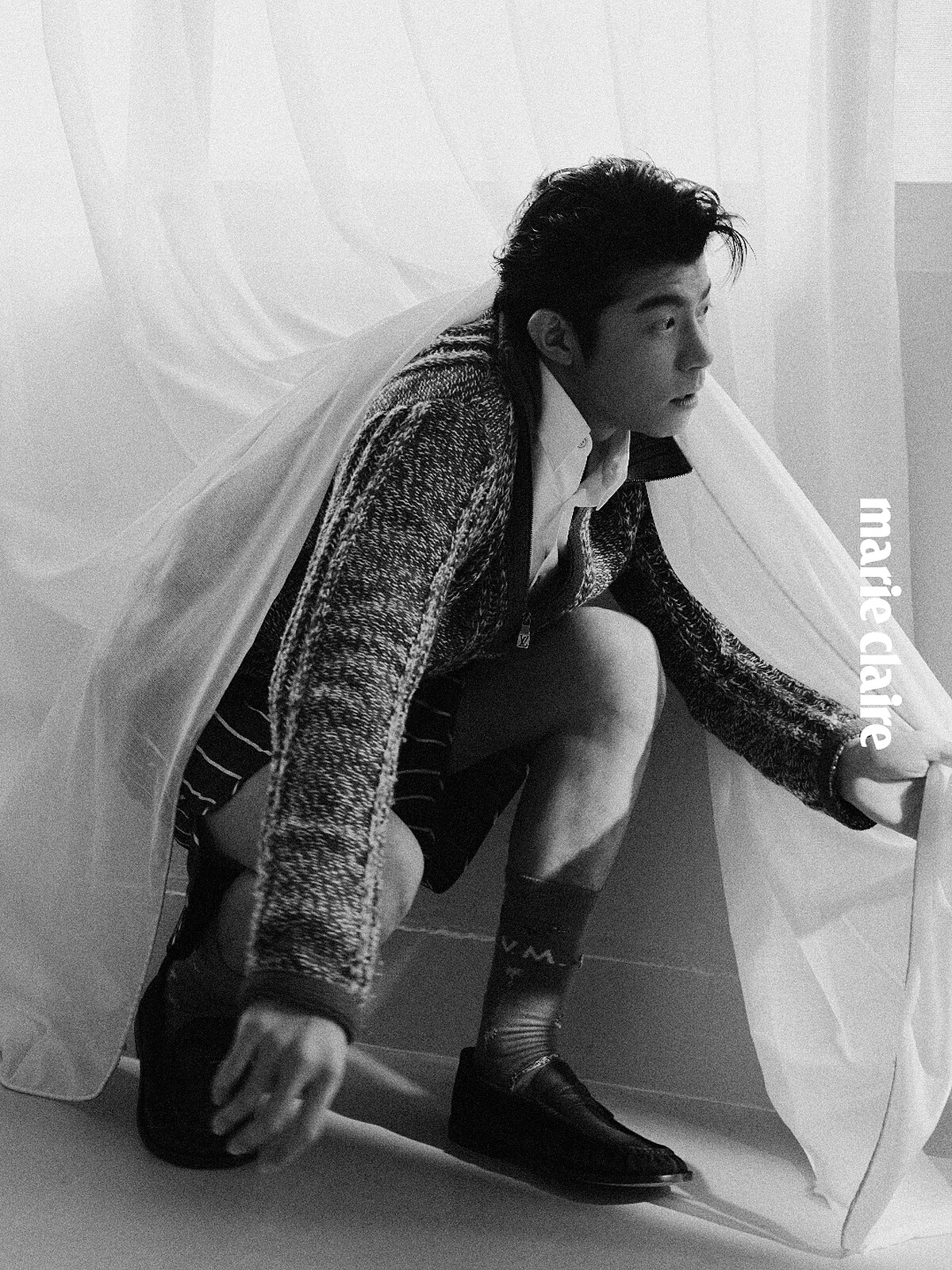 開領拉鍊紫色毛衣、白色襯衫、咖啡色線條短褲、 橘色動物長襪、咖啡色樂福鞋、銀戒指，all by Louis Vuitton。