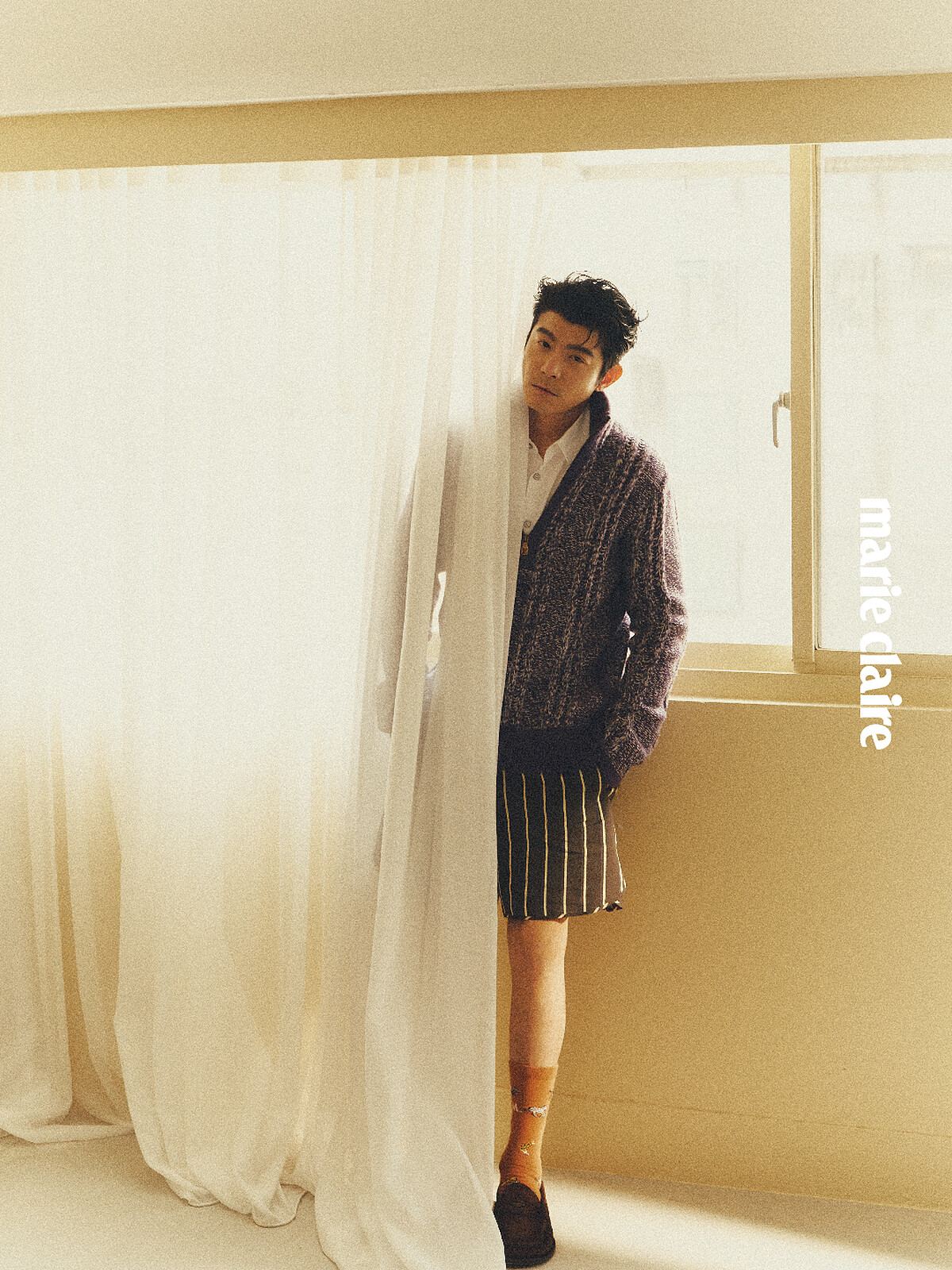 開領拉鍊紫色毛衣、白色襯衫、咖啡色線條短褲、 橘色動物長襪、咖啡色樂福鞋、銀戒指，all by Louis Vuitton。