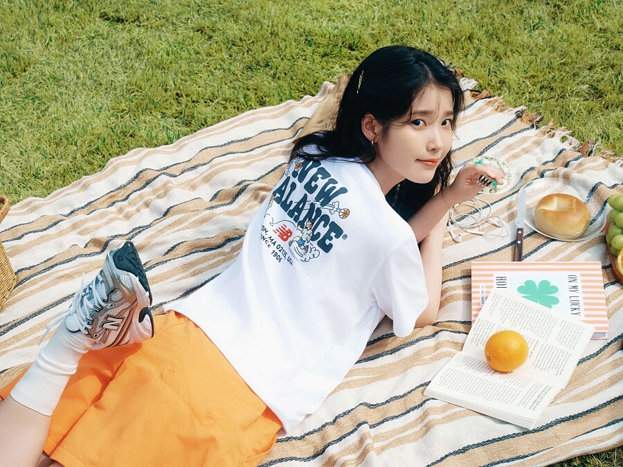 IU以簡單輕鬆的手繪T恤、橘色短褲造型，搭配740新色系鞋款。