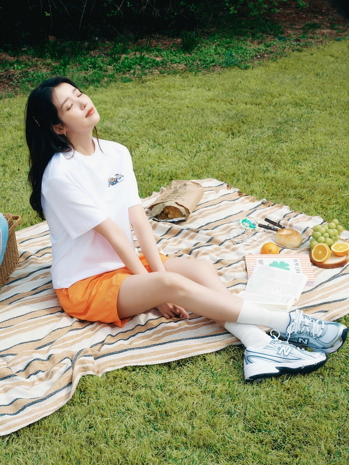 IU以簡單輕鬆的手繪T恤、橘色短褲造型，搭配740新色系鞋款。