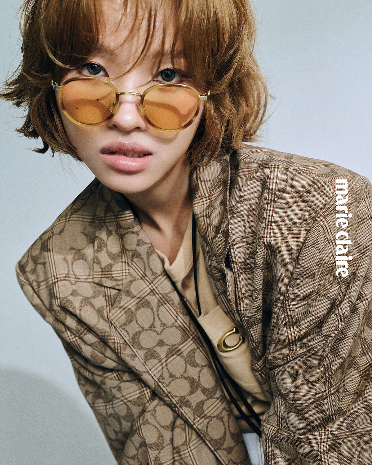 SIGNATURE C 格紋單排釦紳裝外套、圓領棉質上衣、珍珠裝飾造型掛鍊、KISSLOCK 皮革頸掛小包、金屬圓框太陽眼鏡，all by Coach。