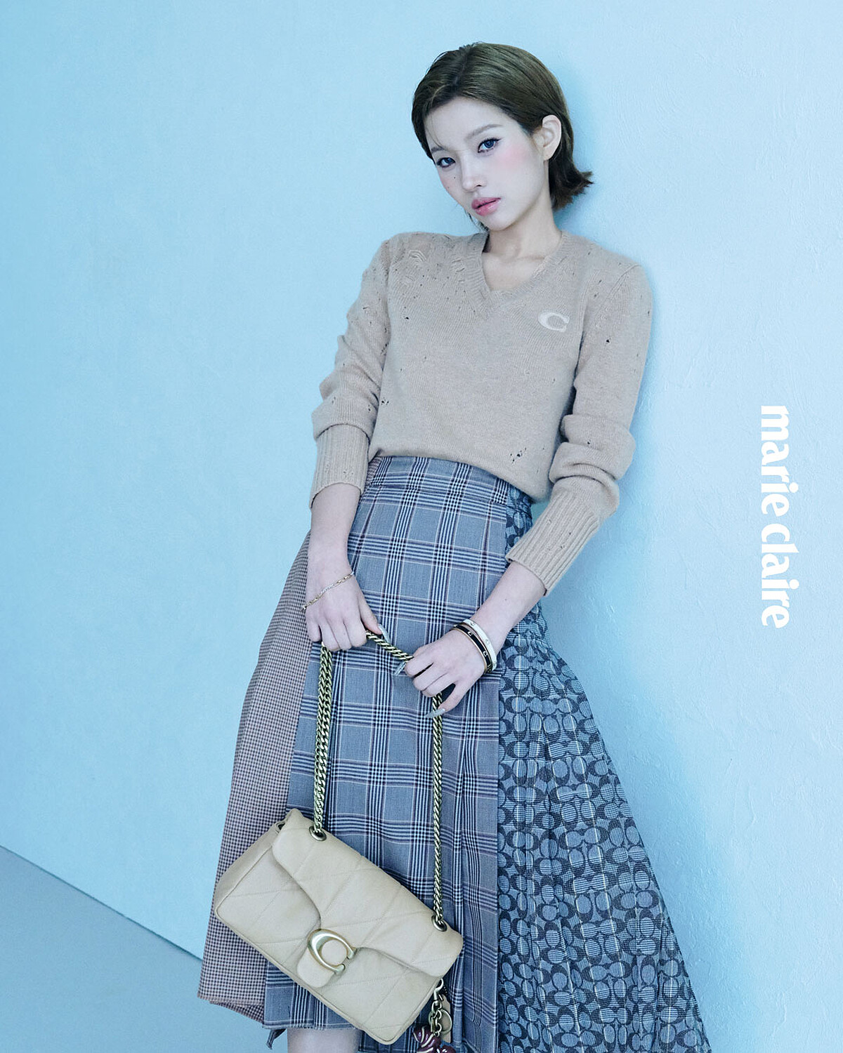 復古長袖 V 領毛衣、HERITAGE 格紋百褶裙、經典 SIGNATURE 纖巧型琺瑯手鐲、經典 SIGNATURE 鏈條手環、TABBY 26 絎縫單肩手袋，all by Coach。