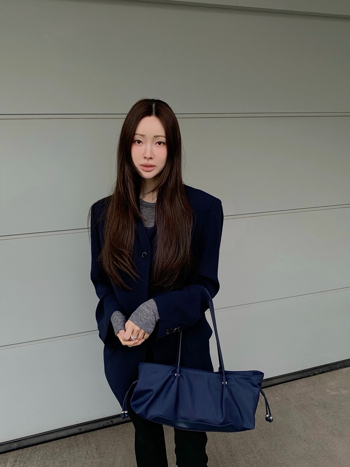 車貞媛以深色西裝搭配長柄東西肩背包。