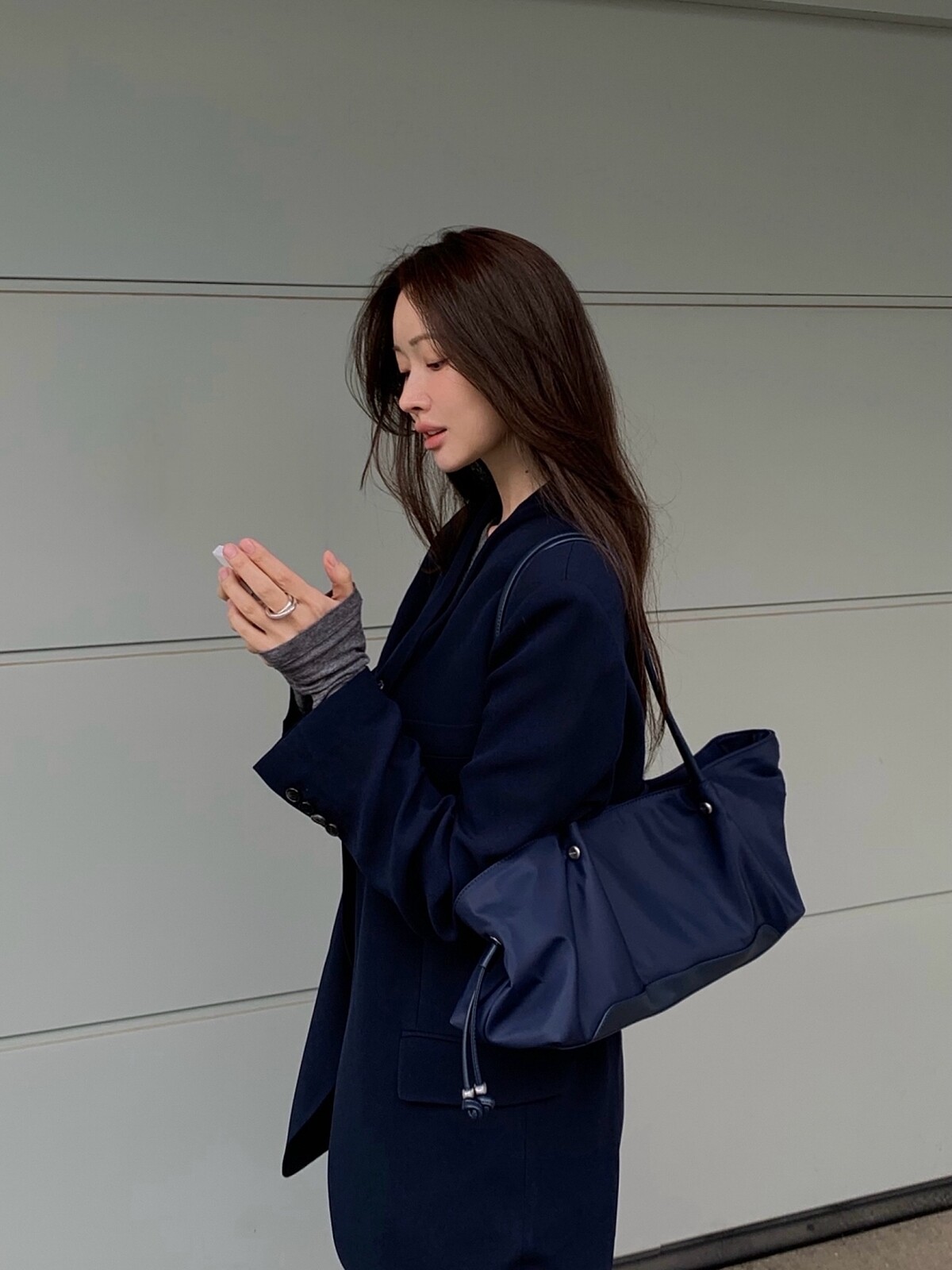 車貞媛以深色西裝搭配長柄東西肩背包。