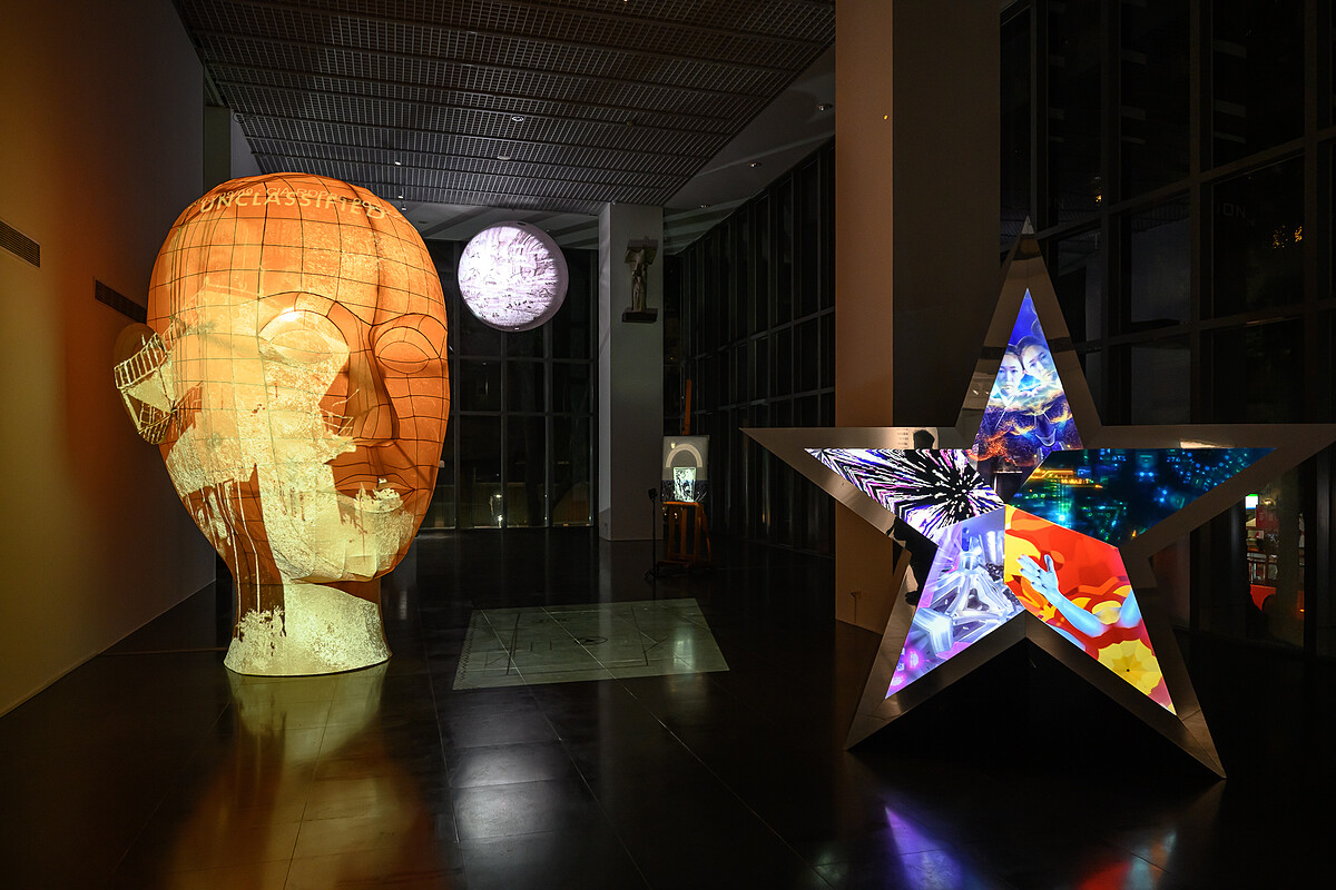 湯尼・奧斯勒 Tony Oursler，《第三眼》，2026，多頻道錄像裝置，不鏽鋼鏡面、布燈籠、金屬、塑膠、燈光、投影，尺寸依空間而異｜北師美術館提供，攝影：王世邦 Anpis Wang