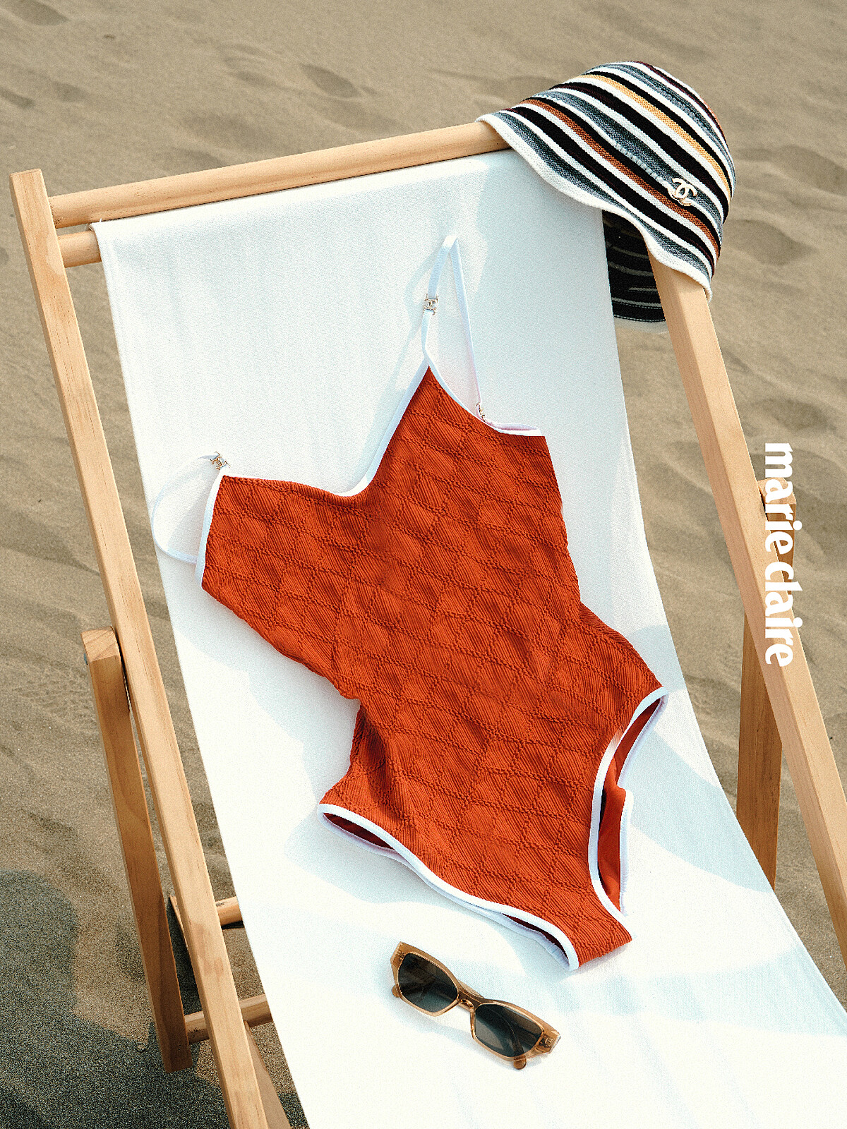 紅白針織連身泳衣、多彩條紋雙 C LOGO 鐘型帽、淡棕色雙 C LOGO 貓眼型太陽眼鏡，all by Chanel。