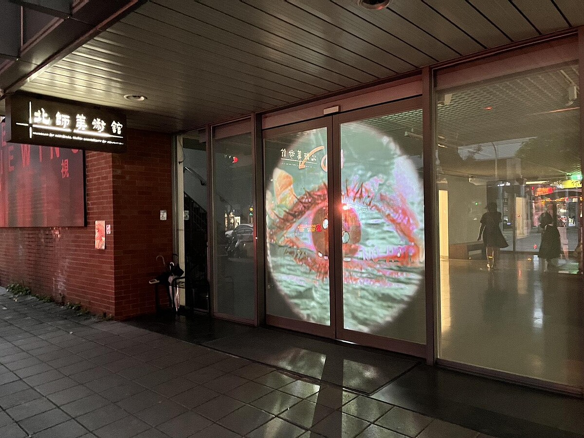 「遙視」展期間,北師美術館一樓玻璃牆於18:30-22:30閉館時間播映湯尼・奧斯勒(Tony Oursler)《第三眼》為北師美術館特別呈現的夜間版本。|Melody TU 採訪拍攝