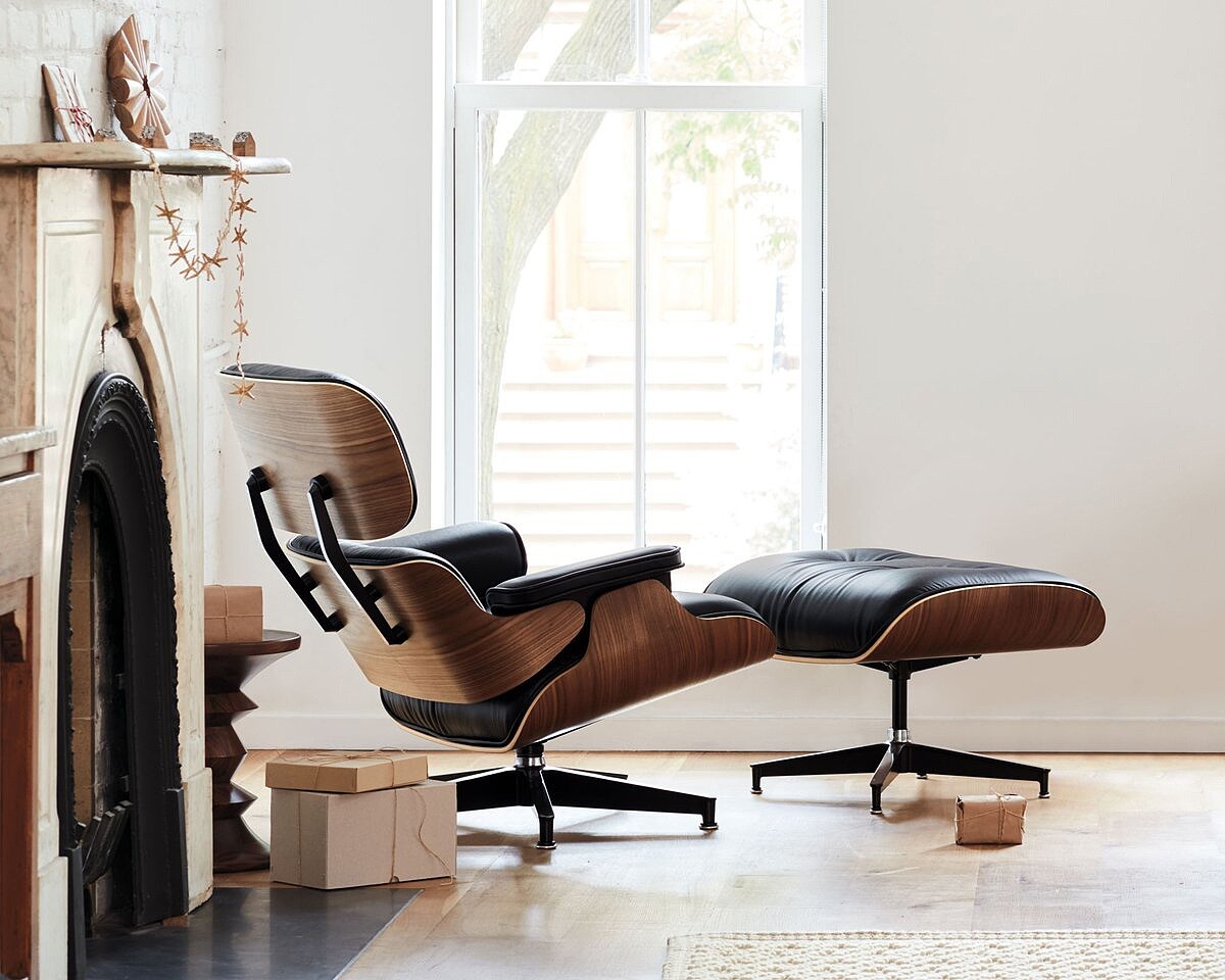 Eames 用模壓木殼和皮革軟墊重新詮釋，讓它同時具備工業時代的精準與手工傢俱的溫度。