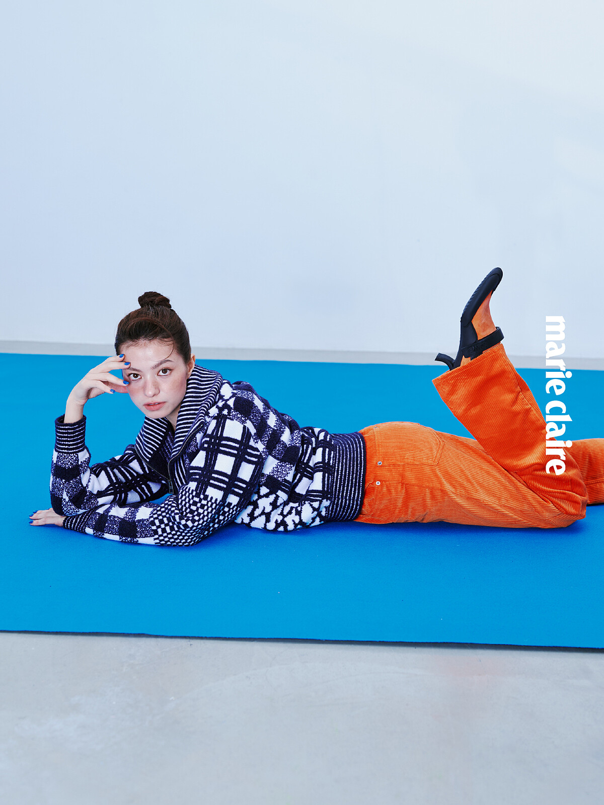 海軍藍與白色拉鍊毛衣、橘色長褲,項鍊,all by Loewe。