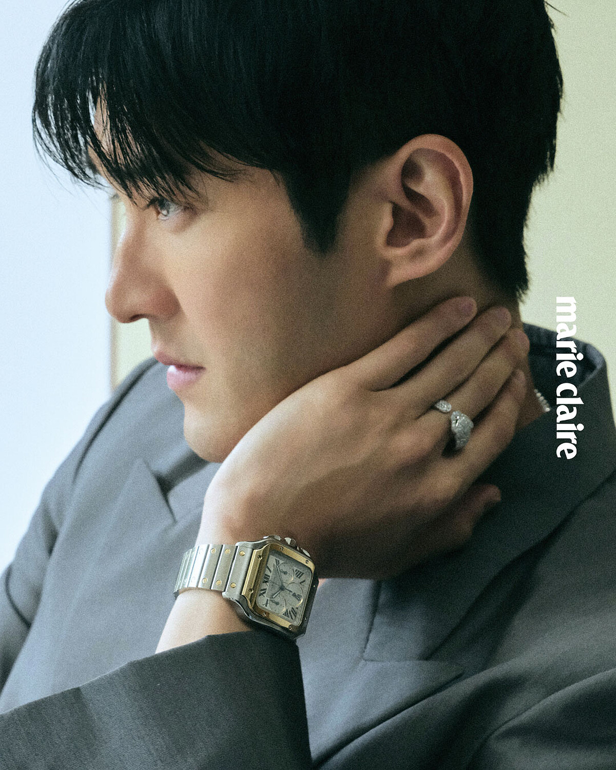 灰色絲質羊毛西裝外套、灰色絲質羊毛褲、黑色皮鞋,all by Gucci; Santos de Cartier 計時碼錶、Clash de Cartier 軟鍊長項鍊, Panthère de Cartier 美洲豹鑽石戒指,all by Cartier。