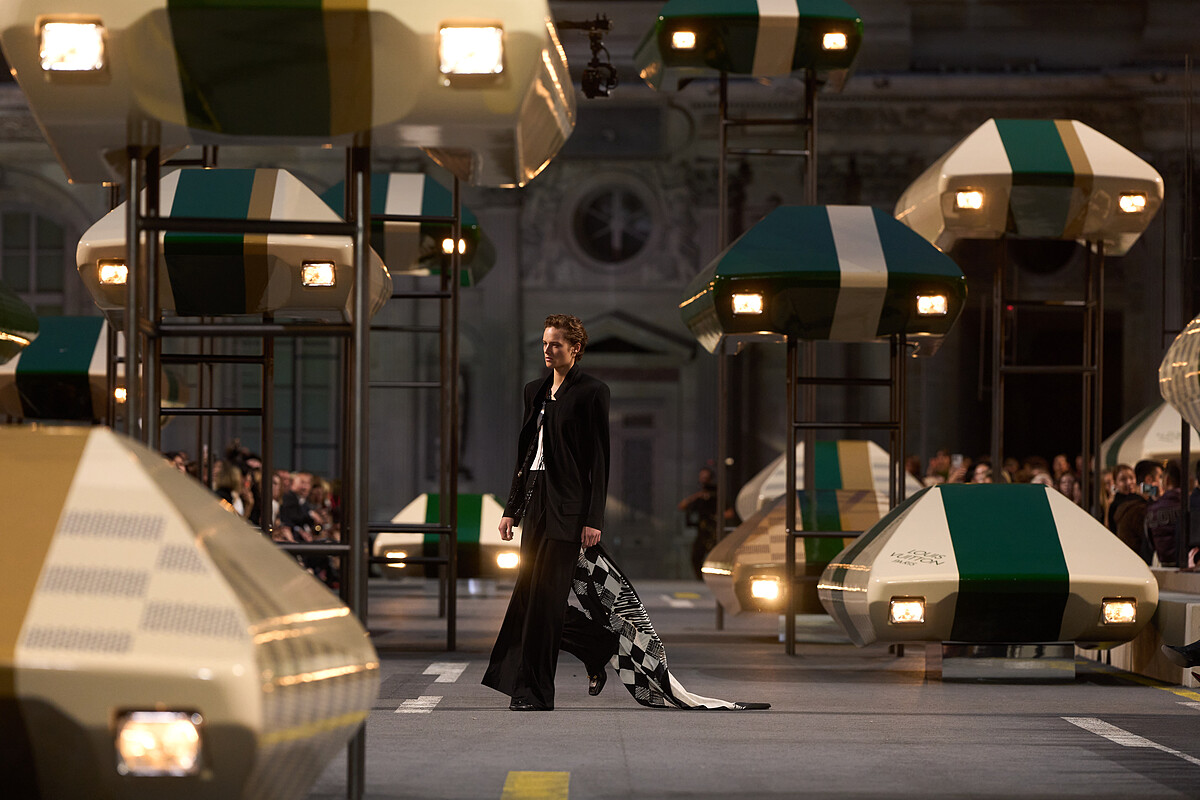 OUIS VUITTON 2027春夏大秀將34輛概念車懸浮於羅浮宮方形庭院上空,古典建築與未來主義景觀交織出令人驚豔的超現實場景。