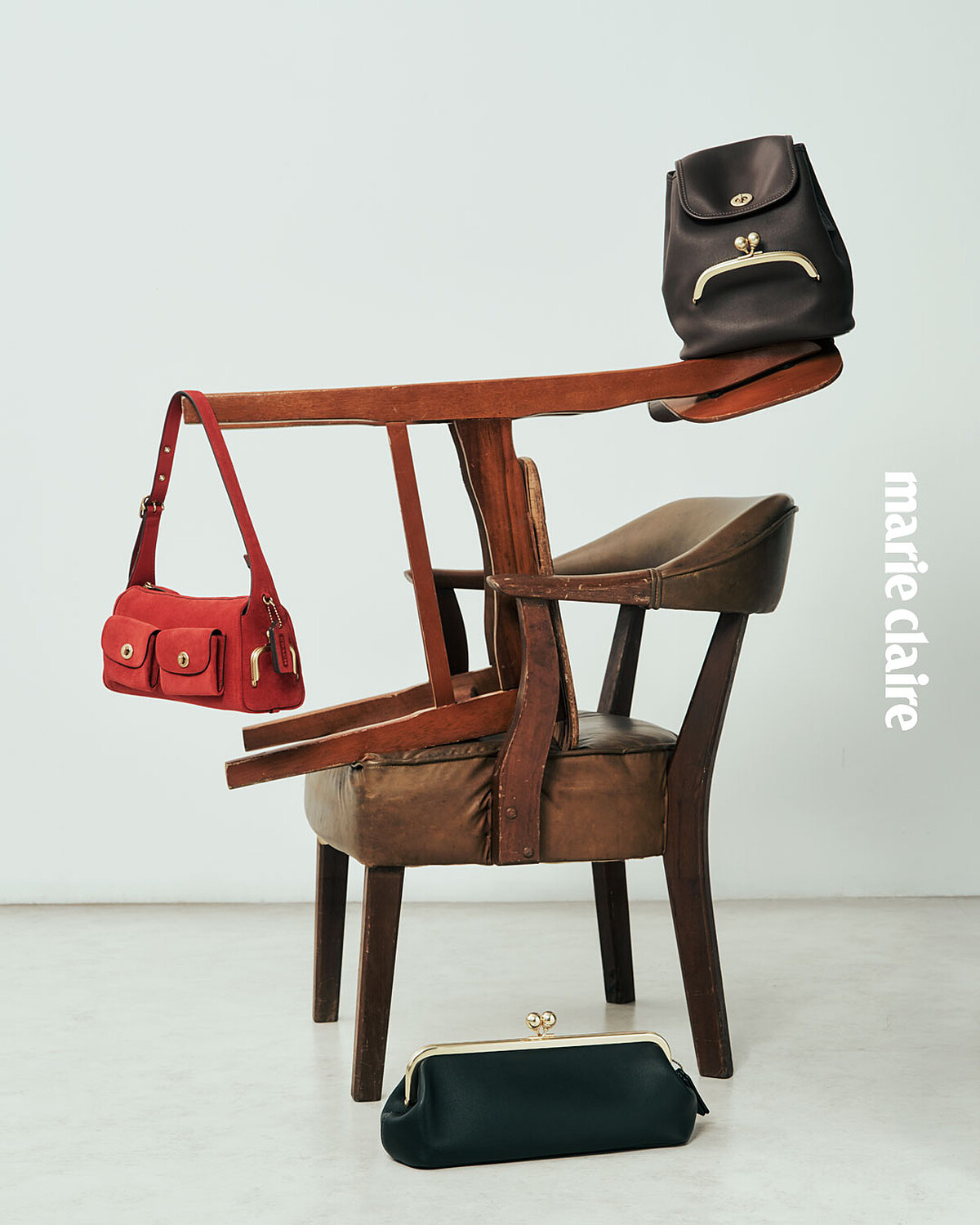 (左起)紅色麂皮 TURNLOCK HAVERSACK 背包、黑色 KISSLOCK BACKPACK、黑色 KISSLOCK FRAME 30 包款,all by Coach。
